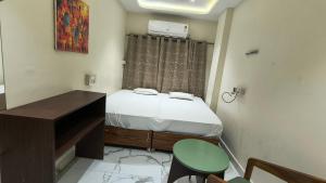 a small bedroom with a bed and a desk at Hotel flexistays central dhantoli in Dhantoli