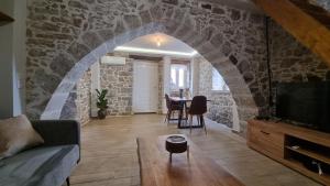 a living room with a stone wall and a table at MENELAUS Stone House in Fourní +65 photos