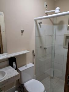 a bathroom with a toilet and a glass shower at Cristal park flats in Cristalina