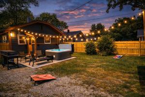 ein Garten mit Pool und ein Haus mit Beleuchtung in der Unterkunft Broad Ripple Home witth Hot Tub Near Downtown Indy in Indianapolis