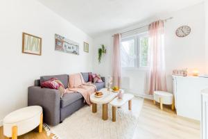 a living room with a couch and a table at Le Cocoon d'Alfortville - Aux portes de Paris in Alfortville