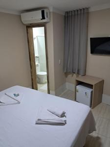 a room with a bed with two towels on it at Cristal park flats in Cristalina