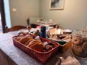 a table with baskets of bread and pastries on it at B&B il Baciass in Pinerolo
