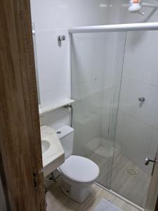 a bathroom with a toilet and a glass shower at Cristal park flats in Cristalina +17 photos