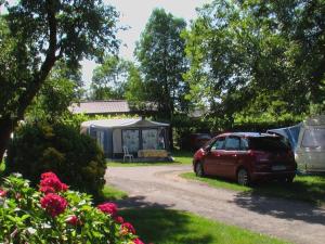 a red car parked in a yard with tents at Chalet 4 pers avec Terrasse à Capvern - API-1-52-1745 in Capvern +4 photos