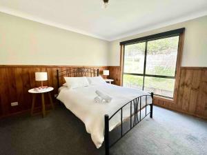 a bedroom with a bed and a large window at Halls Gap House in Halls Gap