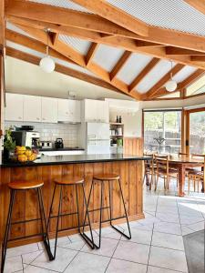 a kitchen with a counter with stools in it at Halls Gap House in Halls Gap