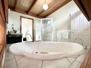 a large white tub in a bathroom with a shower at Halls Gap House in Halls Gap +10 photos