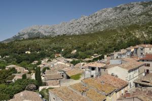 a view of a town in front of a mountain at Le cabanon in Puyloubier