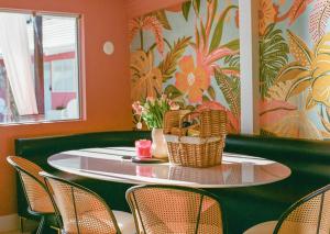 a table with baskets on it in a room with chairs at The Muse Hotel in Palm Springs +2 photos