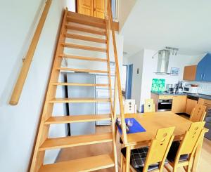 a wooden staircase in a kitchen with a table and chairs at Fewo Weitblick - helle Wohnung, 2 SZ, Wasserblick in Breege +11 photos