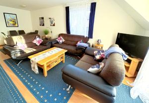 a living room with two couches and a tv at Fewo Wellenherz - mit Balkon, 3 SZ, nah am Hafen in Breege