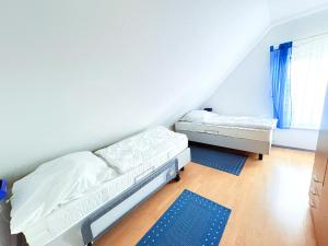 a bedroom with two beds and a window at Fewo Wellenherz - mit Balkon, 3 SZ, nah am Hafen in Breege