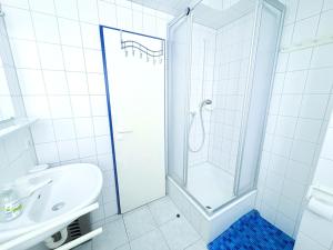 a white bathroom with a shower and a sink at Fewo Wellenherz - mit Balkon, 3 SZ, nah am Hafen in Breege +8 photos
