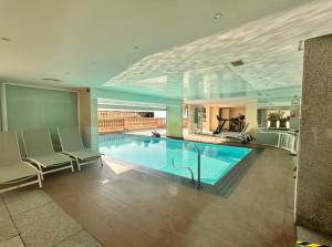 a large swimming pool with two chairs and a table at Victoria Palace T2 de 50m2 in Menton