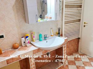 a bathroom with a white sink and a mirror at Appartamenti Cangini in Cesenatico