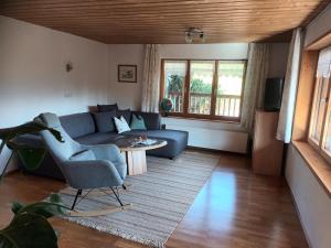 a living room with a blue couch and a table at Haus Hagspiel in Hittisau