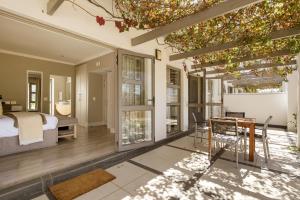 a bedroom with a bed and a table and chairs at Stellenbosch Luxury Apartments in Stellenbosch