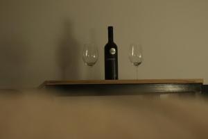 a bottle of wine and two glasses on a shelf at Apartments Peka in Dušanovac (historical) +6 photos
