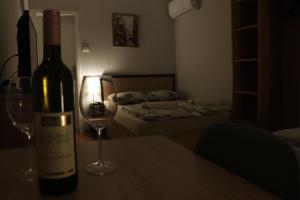 a bottle of wine sitting on a table with a wine glass at Apartments Peka in Dušanovac (historical)