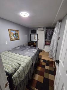 a bedroom with a bed and a television in it at Queen Private room with private bathroom in Irvington