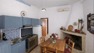 a kitchen with a wooden table and a stove top oven at Shaka guest house in Giba