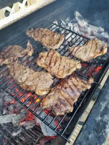 a bunch of meat cooking on a grill at El Corral in Cuenca +13 photos