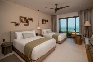 two beds in a hotel room with a view of the ocean at Grand Hyatt Cancun Beach Resort in Cancún