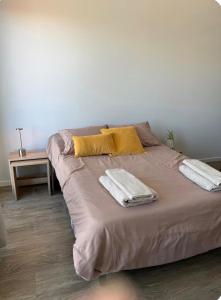 a large bed with two towels on it in a room at Estudio 63 in Neuquén +17 photos
