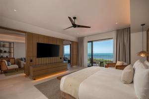 a bedroom with a large bed and a flat screen tv at Grand Hyatt Cancun Beach Resort in Cancún