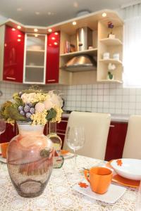 a vase with flowers in it sitting on a table at Apartment Meli Varazdin in Varaždin