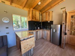 a kitchen with wooden cabinets and a stainless steel refrigerator at Ventana al Castillo in Villa Cerro Castillo