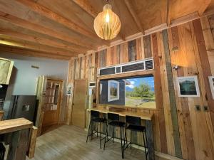 a bar in a cabin with a window and stools at Ventana al Castillo in Villa Cerro Castillo