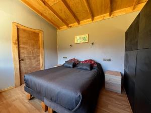 a bedroom with a large bed and a wooden ceiling at Ventana al Castillo in Villa Cerro Castillo