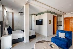 a hotel room with a bed and a couch and a tv at Moderne studio au coeur de rabat in Rabat