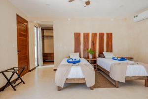 a bedroom with two beds with towels on them at Villas AHAL, in Chemuyil
