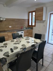 a dining room table with chairs and a kitchen at Le cabanon in Puyloubier