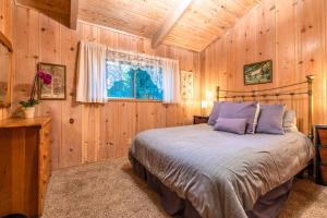 a bedroom with a bed in a wooden cabin at Aunt Ginnys River View in Monte Rio