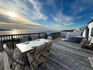 a wooden deck with a table and chairs on it at Bella Oceana in Dillon Beach
