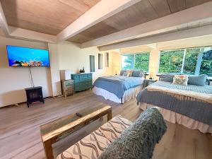a large room with two beds and a flat screen tv at Bella Oceana in Dillon Beach