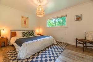 a bedroom with a bed and a table and a chair at Russian River Bungalow in Guerneville
