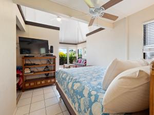 a bedroom with a bed and a flat screen tv at #04 Black Sand Beach Condo in Pahala