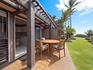 a patio with a wooden table and chairs on a house at #04 Black Sand Beach Condo in Pahala