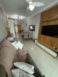 a living room with a couch and a flat screen tv at Apartamento 3 quartos próximo à praia central de BC in Balneário Camboriú