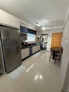 a kitchen with a refrigerator and a table in it at Apartamento 3 quartos próximo à praia central de BC in Balneário Camboriú
