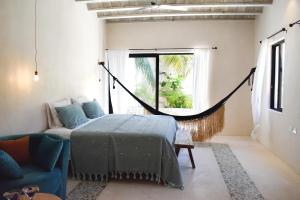 a bedroom with a bed and a couch and a window at Casa Boutique Coco Calin in Sisal +61 photos