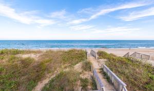a path to the beach with the ocean in the background at Looking Glass - Nags Head MP 12, Oceanfront, Ocean View, Pool, Hot Tub, Pets OK, Flex Stays in Nags Head