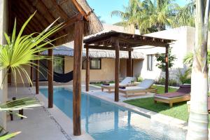 a pool with a hammock and a house at Casa Boutique Coco Calin in Sisal