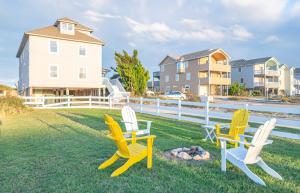 a group of chairs sitting on the grass in a yard at Sea Reunion - Nags Head MP 12.5, Oceanfront, Amazing Views! Pool, Hot Tub, Pets OK in Nags Head