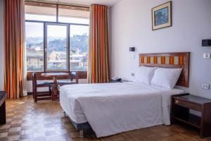 a hotel room with a bed and a large window at Real Hotel Huascaran in Huaraz